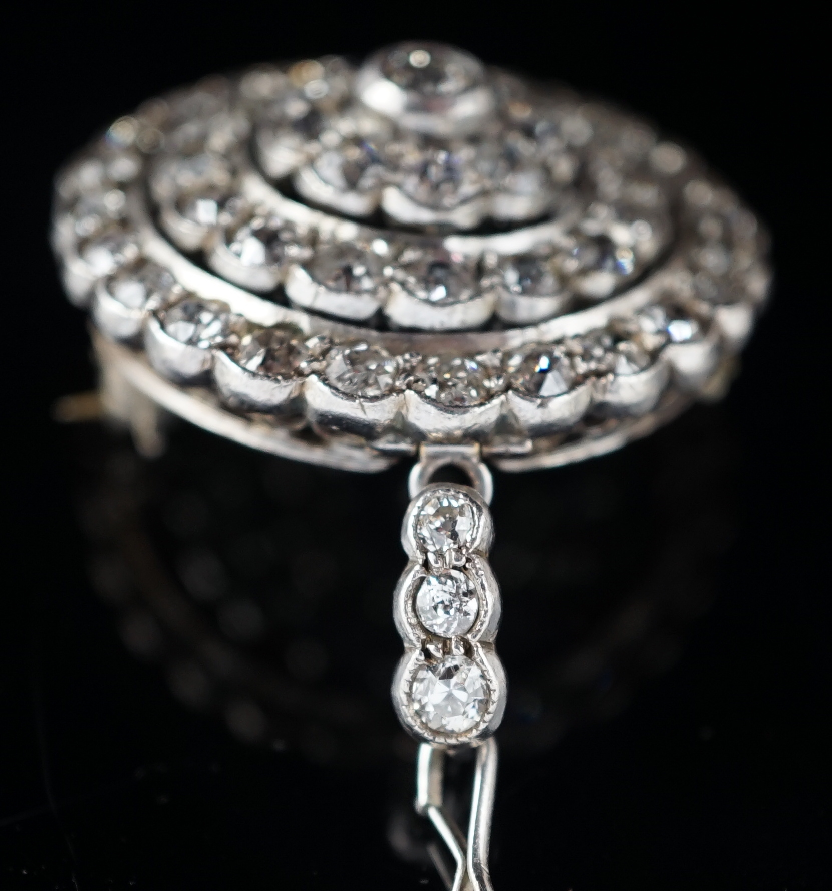 An early 20th century gold, platinum and millegrain set diamond cluster target brooch